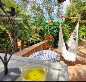 a hammock on a patio with a table and a bowl of mustard at DONNA CATERINA HOUSE in Pietraperzia