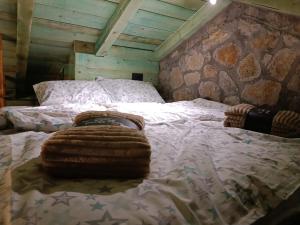 Cama en habitación con pared de piedra en Stone House Montenegro, en Danilovgrad