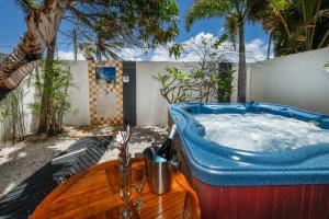 a jacuzzi tub in a backyard with palm trees at Boutique Hotel Swiss Paradise Aruba Villas and Suites in Palm-Eagle Beach
