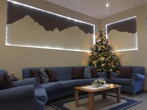 a living room with a blue couch and a christmas tree at Hotel alle Rose in Cavedago