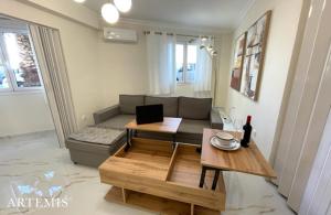 a living room with a couch and a table at MELMA PROPERTIES- ARTEMIS lower ground apartment in front of the Yacht Marina in Piraeus