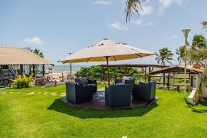 a group of chairs sitting under an umbrella at Pousada Aldeola by Slaviero Hotéis in Baixio
