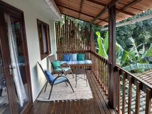 a porch with chairs and a couch on it at Casa Verde in Rio de Janeiro