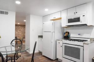 een keuken met witte kasten en een glazen tafel bij Cozy Mount Washington Home with Parking-Sleeps 4 in Pittsburgh