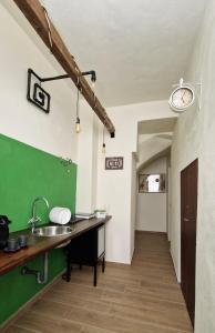 a kitchen with a sink and a clock on the wall at LE SEGRETE DEL POZZO in Capurso
