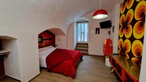 a bedroom with a bed with a red blanket at LE SEGRETE DEL POZZO in Capurso