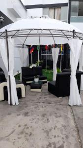 a gazebo with black and white furniture under it at Venecia Hotel Carrion in Trujillo