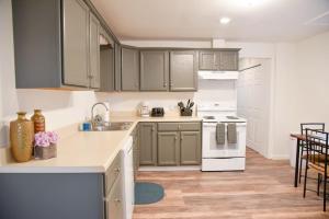 a kitchen with gray cabinets and white appliances at Relax & Feel At Home During Your Pittsburgh Stay in Pittsburgh