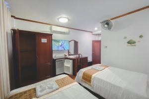 a hotel room with two beds and a tv at Khampiane1 Hotel in Ban Nongdouang