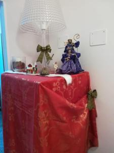 フォンディにあるA Casa d'Antonellaの赤いテーブルクロスと置物が置かれたテーブル