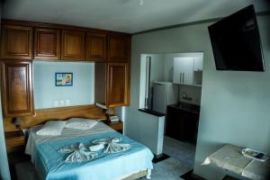 Dormitorio pequeño con cama y nevera en Hotel Bauer, en Torres