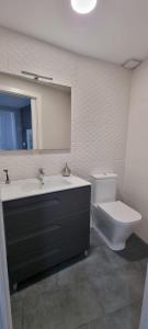 a bathroom with a sink and a toilet and a mirror at Virrey del Pino - Apartamento en Baena in Baena +16 photos