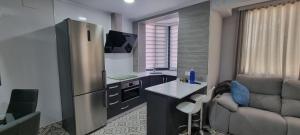a small kitchen with a refrigerator and a couch at Virrey del Pino - Apartamento en Baena in Baena