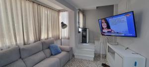 uma sala de estar com um sofá e uma televisão de ecrã plano em Virrey del Pino - Apartamento en Baena em Baena