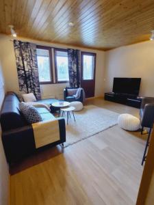 ein Wohnzimmer mit Sofa und Klavier in der Unterkunft Ruka Kierävä with ski tickets in Kuusamo