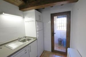 una pequeña cocina con fregadero y ventana en Apartamentos Rurales SPA Casa De Los Escudos, en Valverde de la Vera