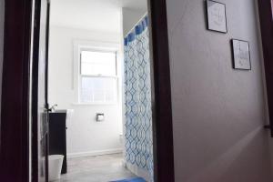 a bathroom with a toilet and a shower door at Beautiful 3 Bedroom Home Cozy Front and Back Porch in Munhall