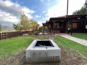 a fire pit in a yard in front of a house at Kapilio Cottage House in Kapilio
