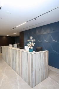 a lobby with a reception counter with a flower arrangement at Hotel Partner in Vlorë