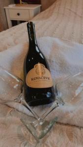 a bottle of wine sitting on a bed at Apartman17 in Belgrade