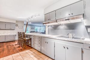 uma cozinha com armários brancos e uma mesa e cadeiras em Rhododendron Retreat em Rhododendron