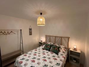 a bedroom with a bed with a comforter and a lamp at Les Gites du Verdon, côté lac (studio et T2) in Sainte-Croix-de-Verdon