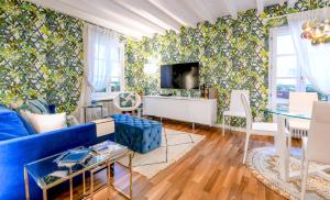 Una sala de estar con un sofá azul y un televisor. en Glow - by MyHomeInComo, en Como