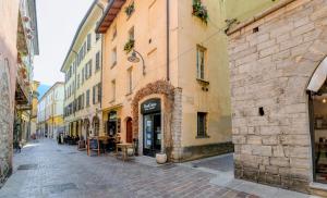 un callejón en una ciudad con edificios, mesas y sillas en Glow - by MyHomeInComo, en Como