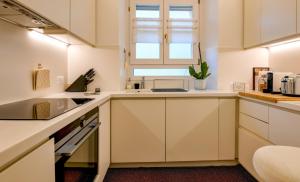 Una cocina con gabinetes blancos y una ventana. en Glow - by MyHomeInComo, en Como