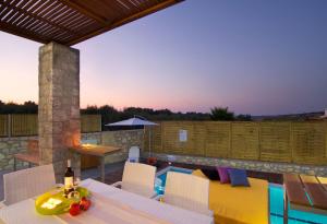 a patio with a table and chairs and a pool at Villa Aada - moderne Komfortvilla mit eigenem Pool in Loutra