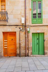 dos puertas verdes y naranjas al lado de un edificio en Dúplex Camino de Santiago I, II y III, Rúa Real 26 y 28, Zona Monumental, Pontevedra, en Pontevedra