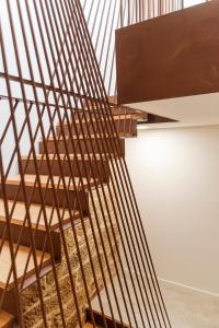 a wooden spiral staircase with a metal railing at Dúplex Camino de Santiago I, II y III, Rúa Real 26 y 28, Zona Monumental, Pontevedra in Pontevedra