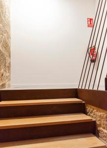 龐特維德拉的住宿－Dúplex Camino de Santiago I, II y III, Rúa Real 26 y 28, Zona Monumental, Pontevedra，白色墙壁的房间的一套楼梯