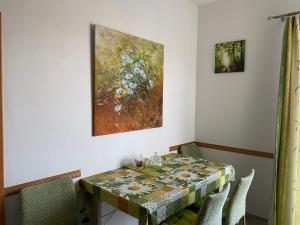 a dining room table with a painting on the wall at Apartmán na Lukách - Kopretina in Třeboň