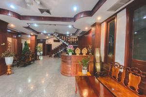 um átrio com mobiliário em madeira e uma escadaria num edifício em Khampiane1 Hotel em Ban Nongdouang