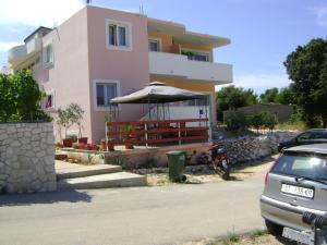 ein Haus mit einem Regenschirm und einem davor geparkt in der Unterkunft Apartments Sanja in Hvar