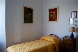 una camera con un letto e due quadri appesi al muro di Agriturismo La Malcontenta e il Lupo a Todi