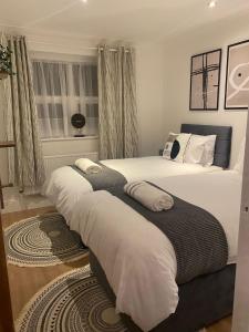 a bedroom with two beds with white sheets at Acacia Villa in Dunstable