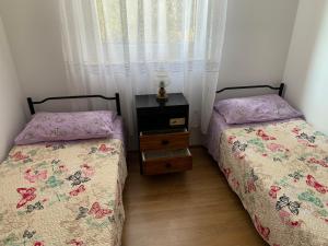 dwa łóżka siedzące obok siebie w sypialni w obiekcie Apartman Ruža w mieście Brzac