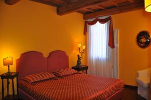 a bedroom with a red bed and a window at Piazza Nova Guest House in Ferrara