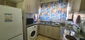 a kitchen with a washing machine and a refrigerator at Beach Break Holiday Flat in Port Shepstone +4 photos
