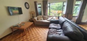 a living room with a leather couch and a coffee table at Beach Break Holiday Flat in Port Shepstone