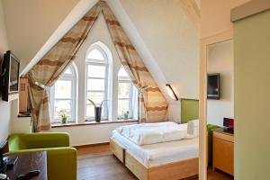 a bedroom with a bed and a large window at Hotel Zur Wartburg in Rheda-Wiedenbrück