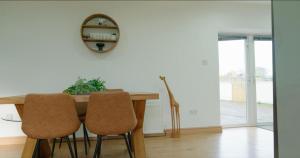 a dining room table with two chairs and a mirror at Unique countryside stay in Dundrod