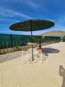 a table and two chairs under a green umbrella at SUN VILLA in Hondón de los Frailes