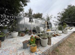 an rv with a bunch of potted plants on a patio at Amy The Airstream At Aloe Fjord in Vaal Marina