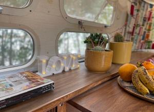 a table with a plate of fruit and a book at Amy The Airstream At Aloe Fjord in Vaal Marina