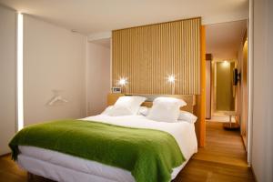 una camera da letto con un grande letto con una coperta verde di Echaurren Hotel Gastronómico a Ezcaray