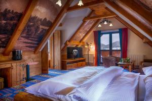 um quarto com uma cama grande num sótão em Wellness Penzion Strachan em Ždiar