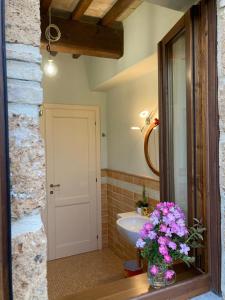 a bathroom with a sink and a vase of flowers at Casale Riorso in Orvieto